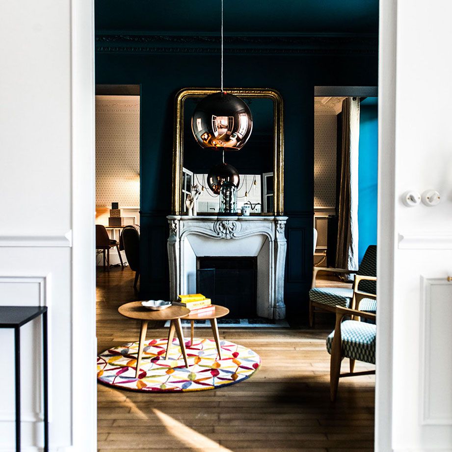 一间深蓝色的房间，里面有一座华丽的白色大理石壁炉