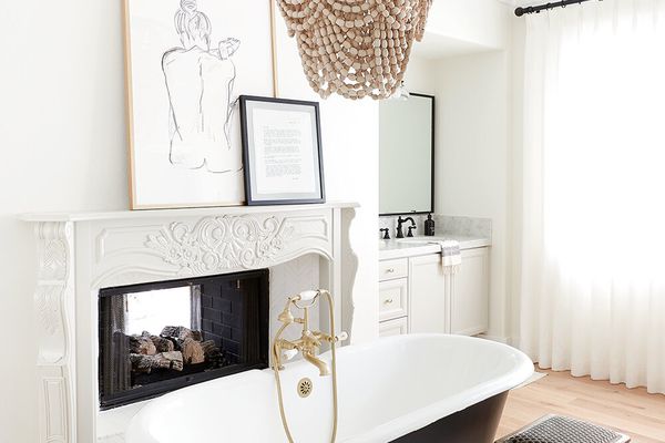 带黑色浴缸和串珠枝形吊灯的时尚的白色浴室