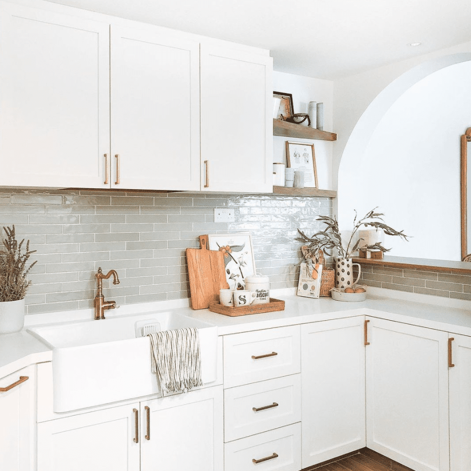 一个白色的小厨房，薄荷绿色的后挡板和光滑的金属五金