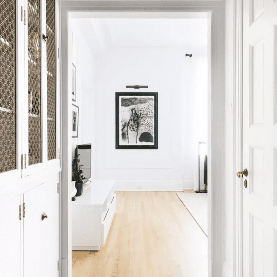 客厅里挂着一幅装裱好的艺术品，上面挂着一盏照明灯