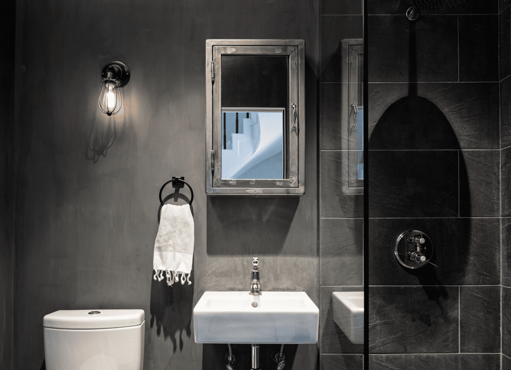 浴室配有黑色瓷砖和混凝土风格的墙壁