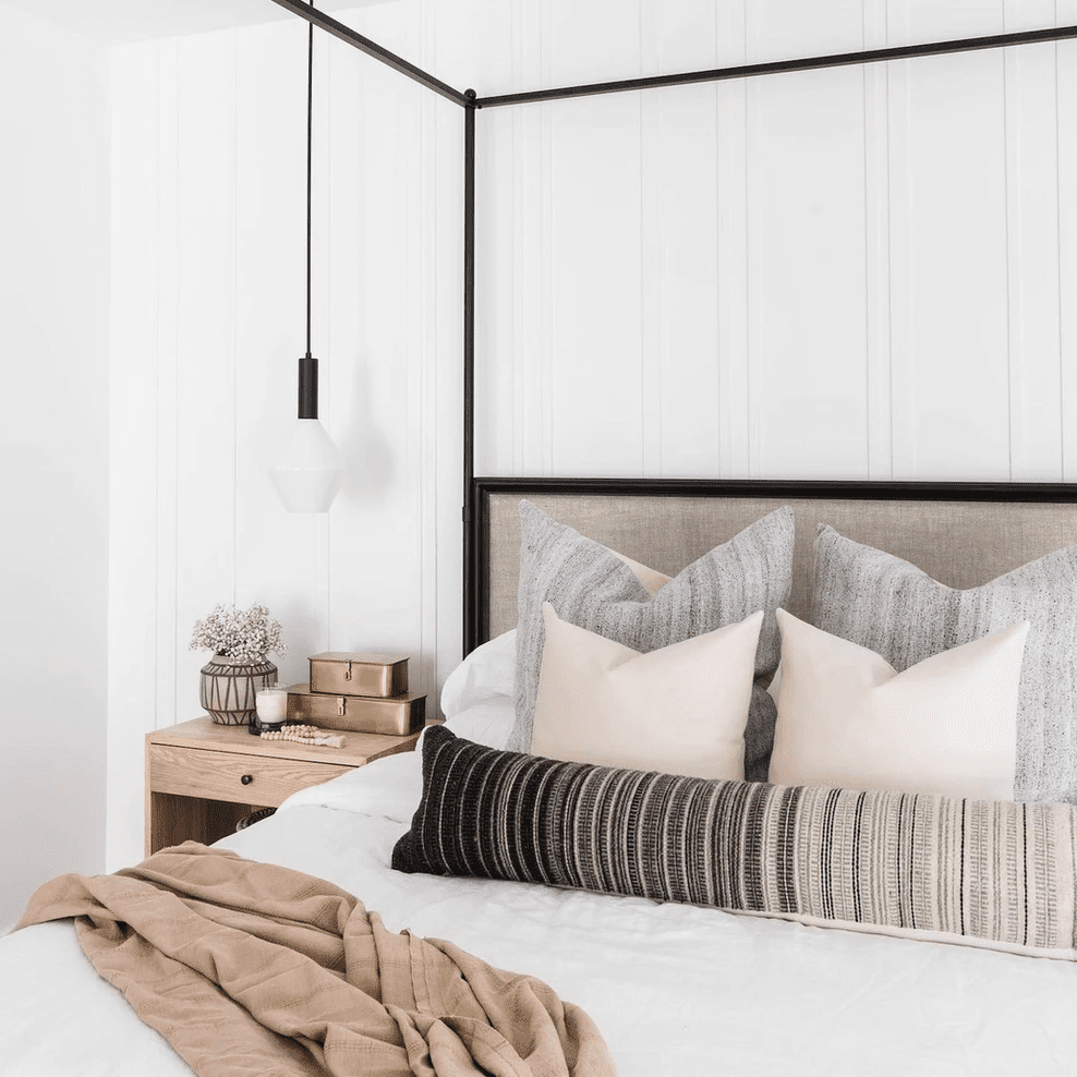 一间有黑色顶篷床架和配套灯具的卧室