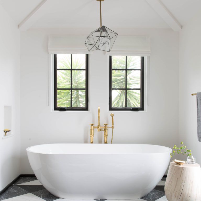 一间带白色浴缸和大型大胆瓷砖的主浴室