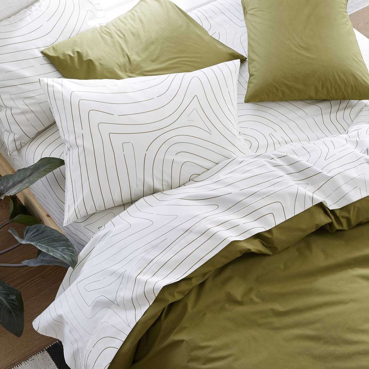用白色的床单与波浪图案和绿色的羽绒床