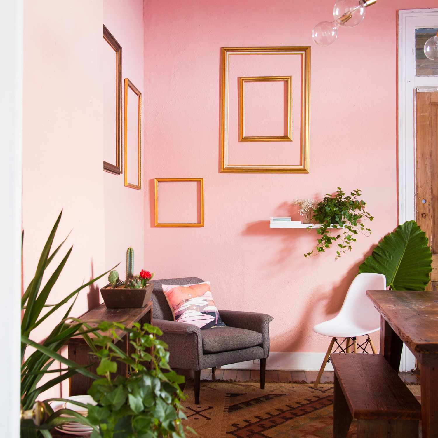 粉红色的餐厅，墙上挂着金色的镜框