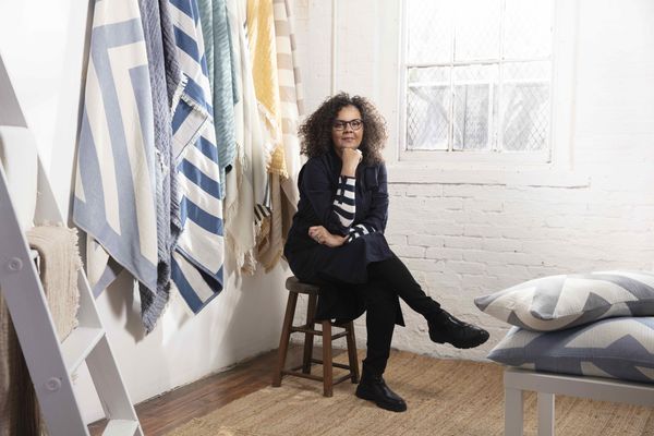 Johanna Howard坐在凳子上，前面是一堆杂物