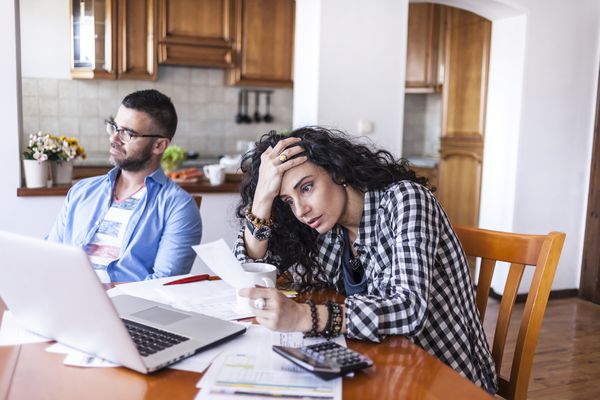一对夫妇在笔记本电脑前看起来很沮丧