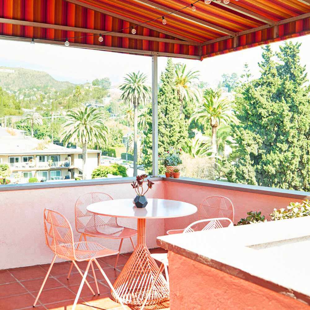 粉红色的阳台装饰着粉红色的桌子和匹配的椅子