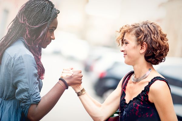 两个女朋友抓住手好像要说，“道歉被接受”。