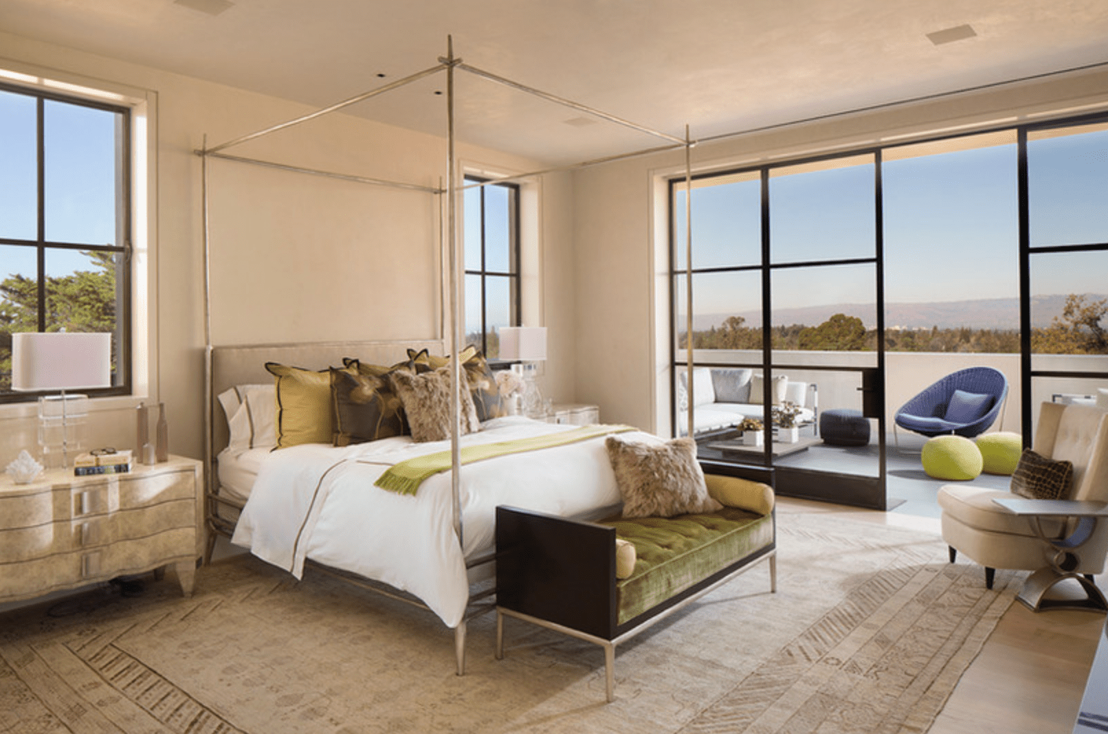 一间卧室通向阳台，阳台上装饰着雕塑和彩色家具