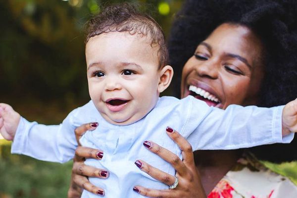 一个女人微笑，手里拿着一张微笑的宝宝。