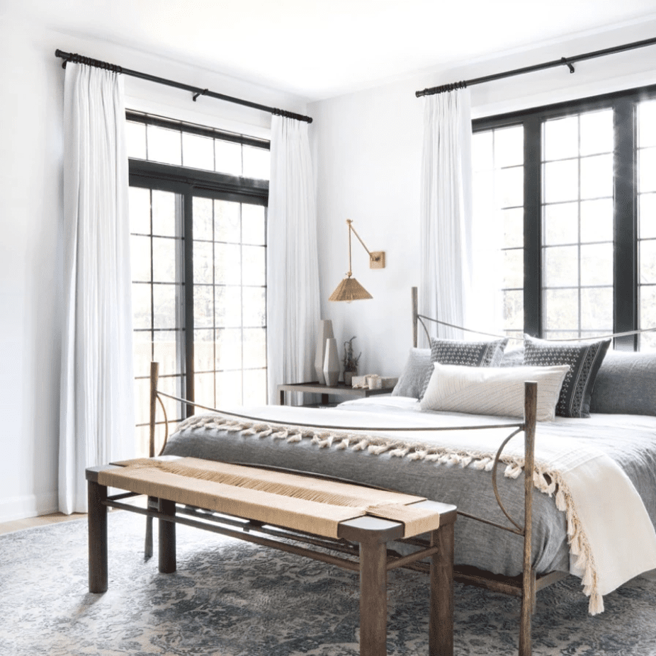 一间带窗帘的卧室，悬挂在天花板到地板