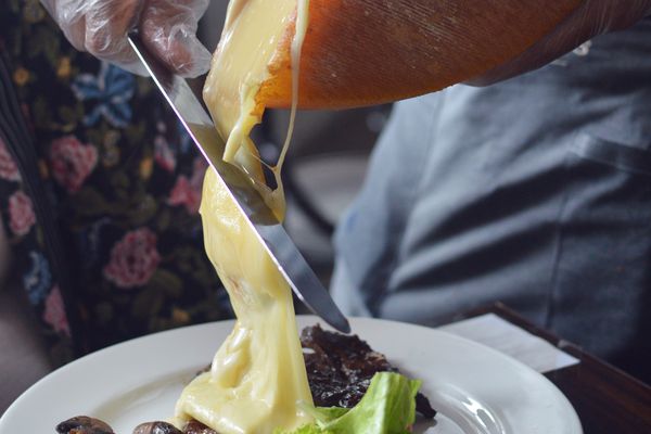 Raclette乳酪轮子用被刮的乳酪被刮在土豆和蘑菇在板材