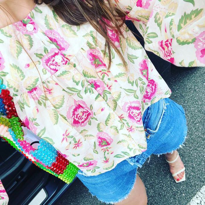 穿着牛仔短裤和印花长袖上衣的女人。