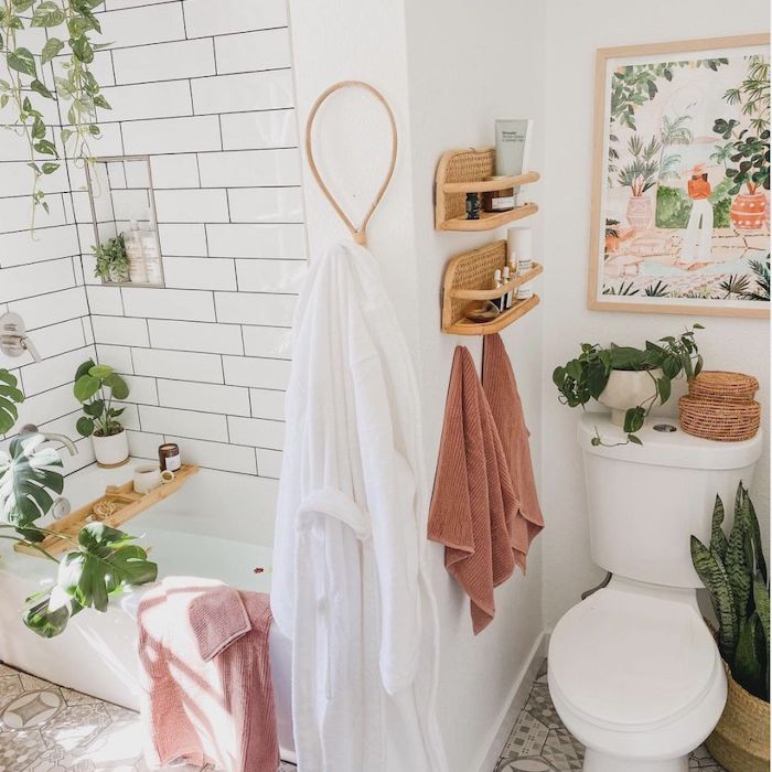 有植物的白色浴室，柳条浮动架拿着物品，与绘画的厕所在它上面