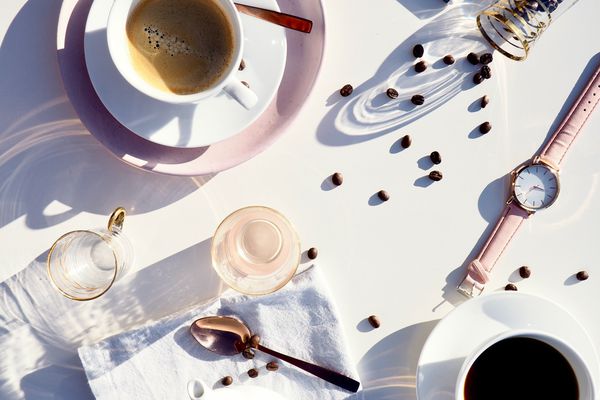咖啡用豆，玻璃和手表在白色桌上