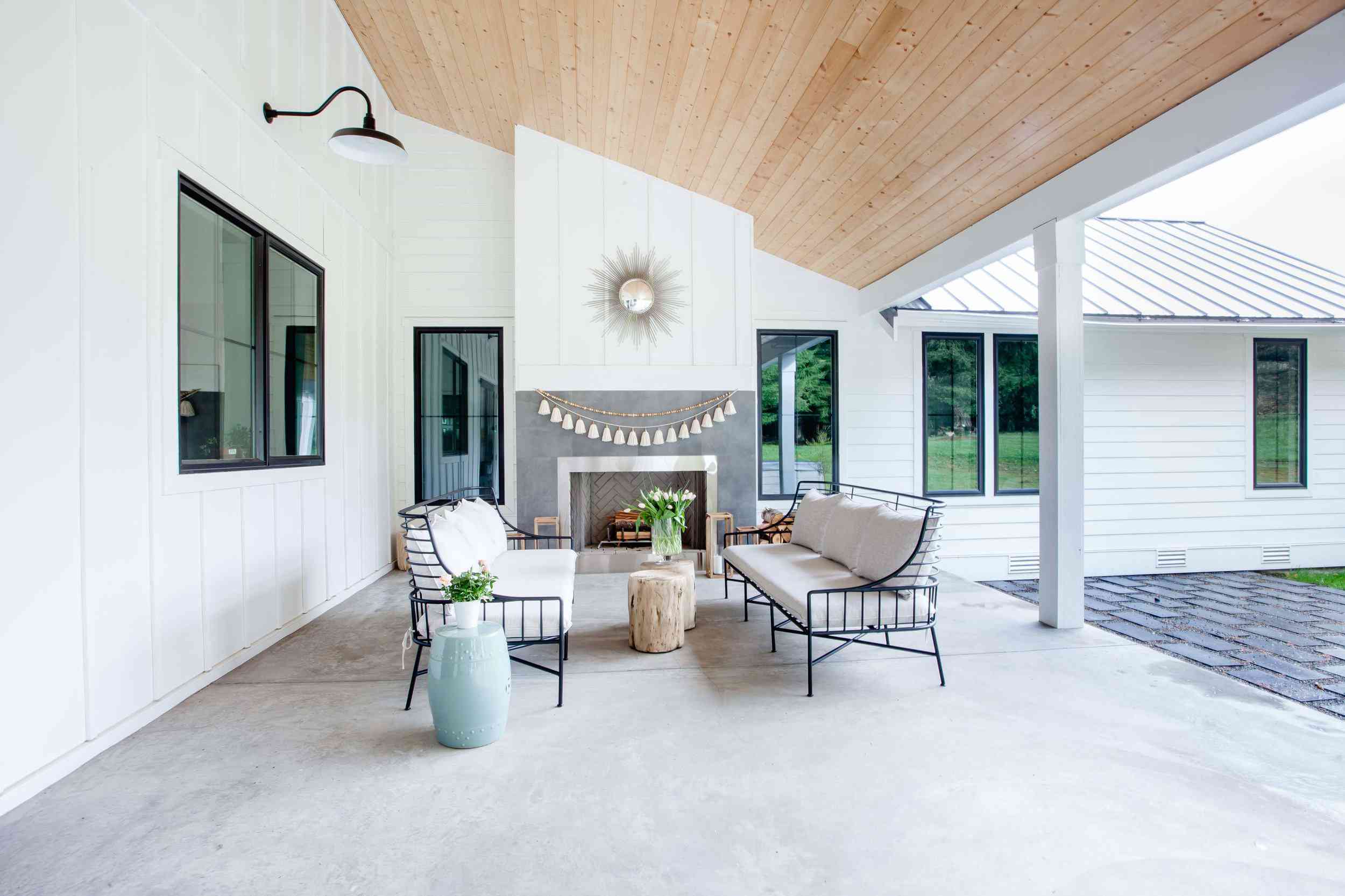 带有户外壁炉的覆盖的露台，装饰有一个边缘衬里的花环