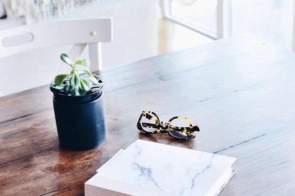 有笔记本眼镜和植物的书桌