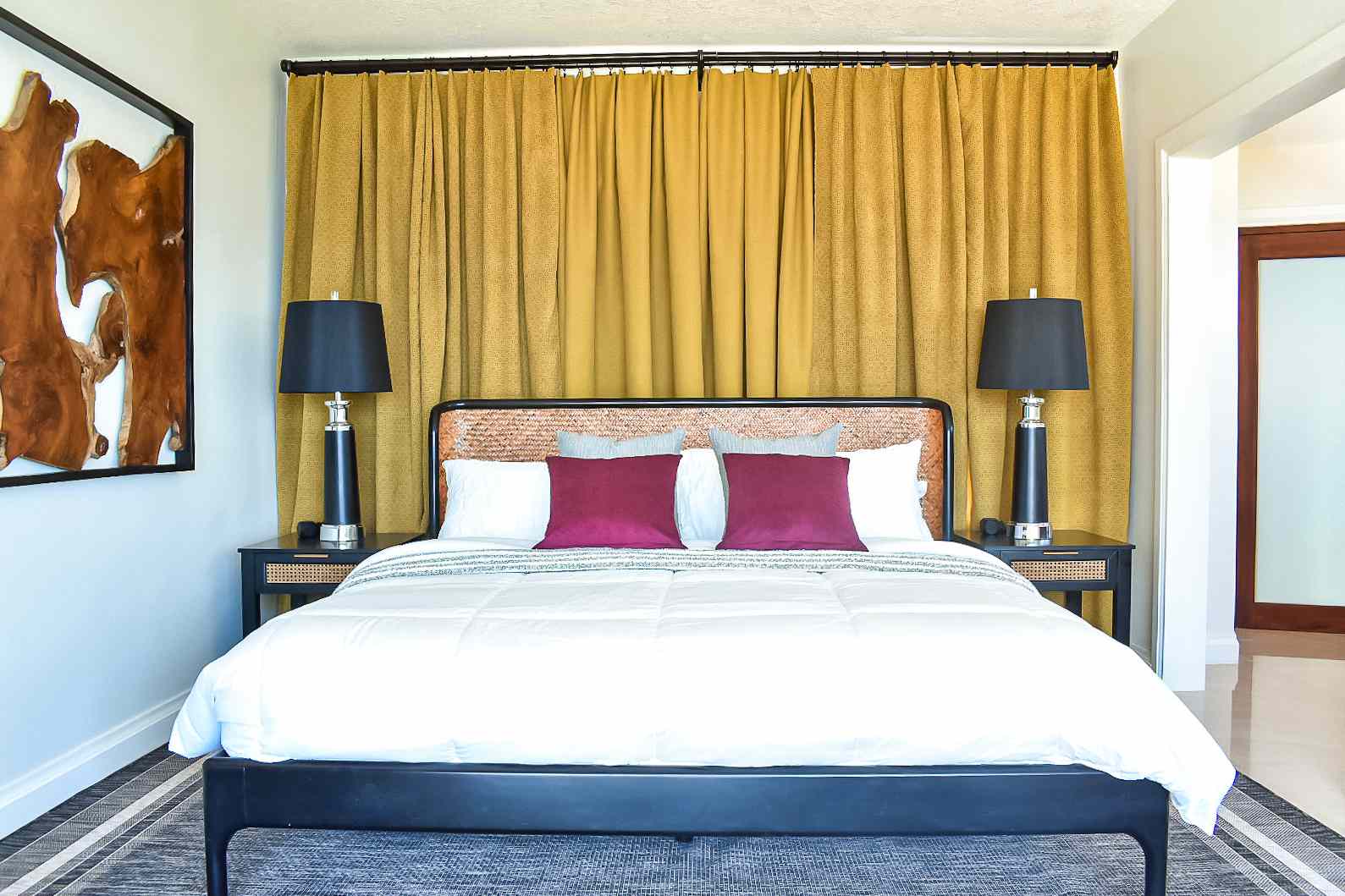 黑色的床，后面挂着黄绿色的窗帘。