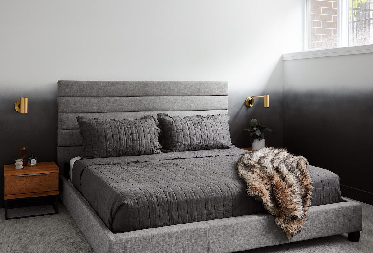 一间全灰色的浴室，配有明亮的金色壁灯