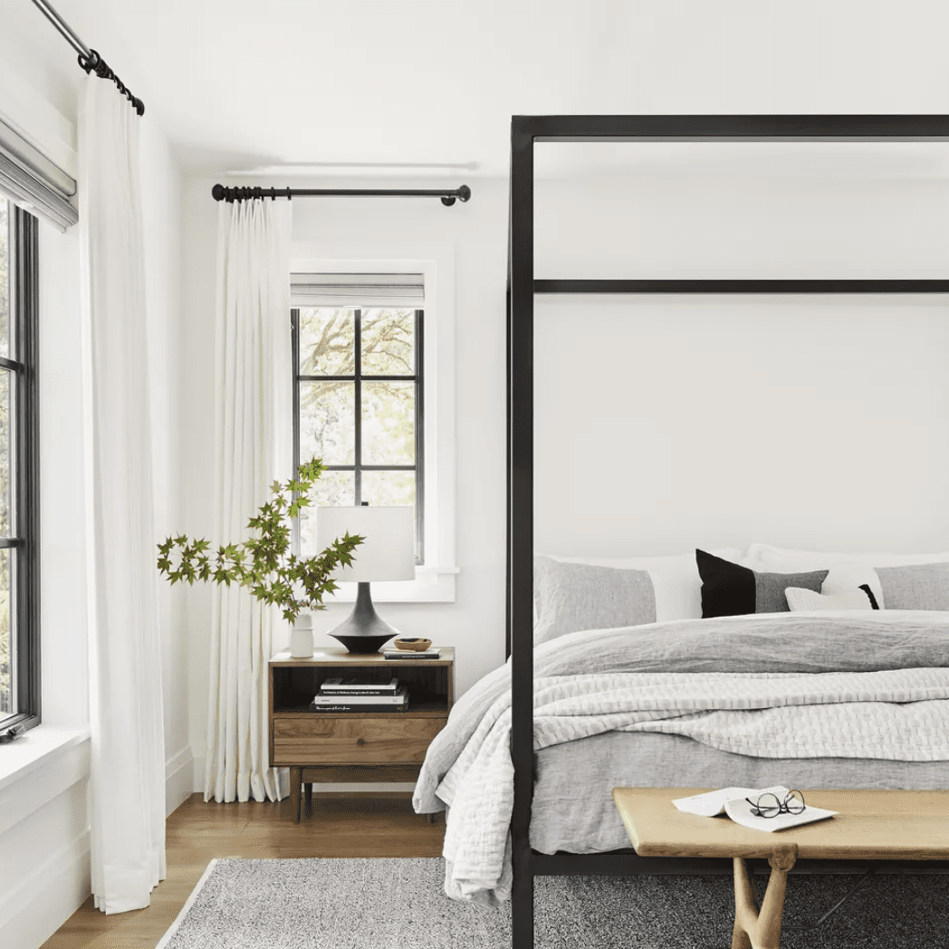 禅卧室，黑色和白色的色调，一个四柱床，轻落地窗帘“class=