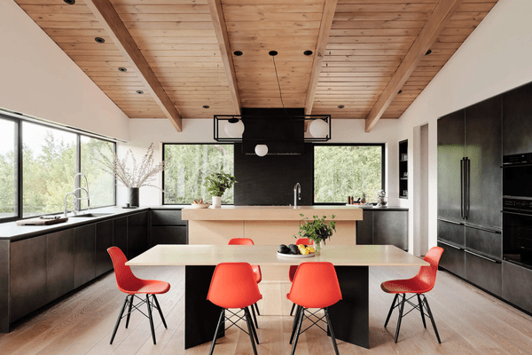 开放式厨房和餐厅，配有醒目的红色椅子