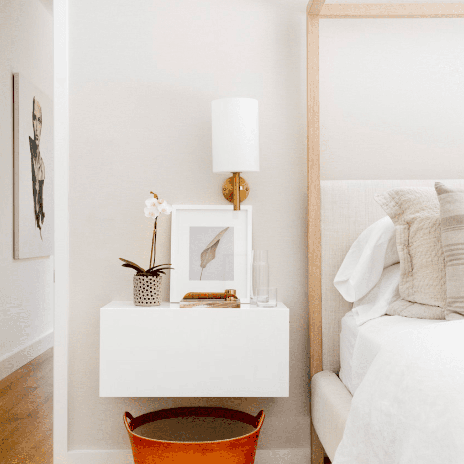 一间全白的卧室，里面有个橙色的皮篮子