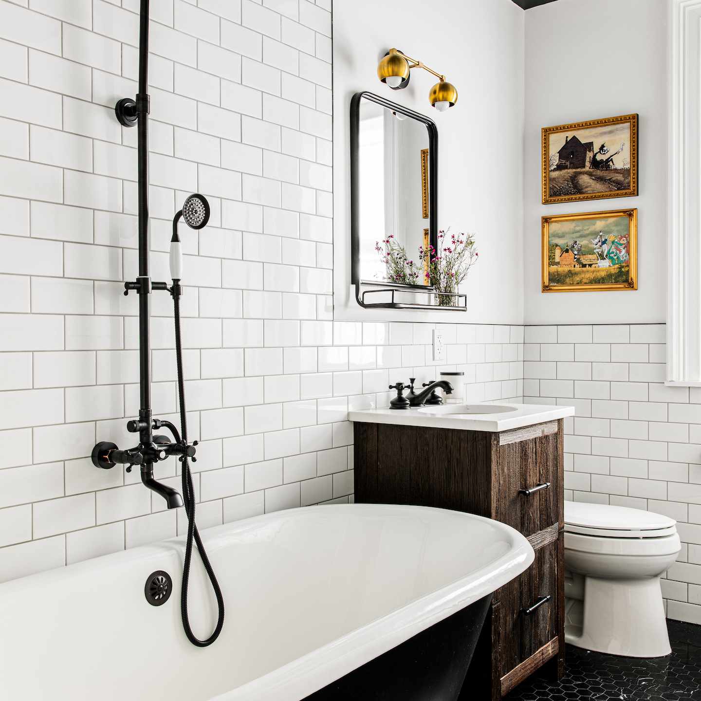 铸铁浴缸在全白色的地铁瓷砖浴室。