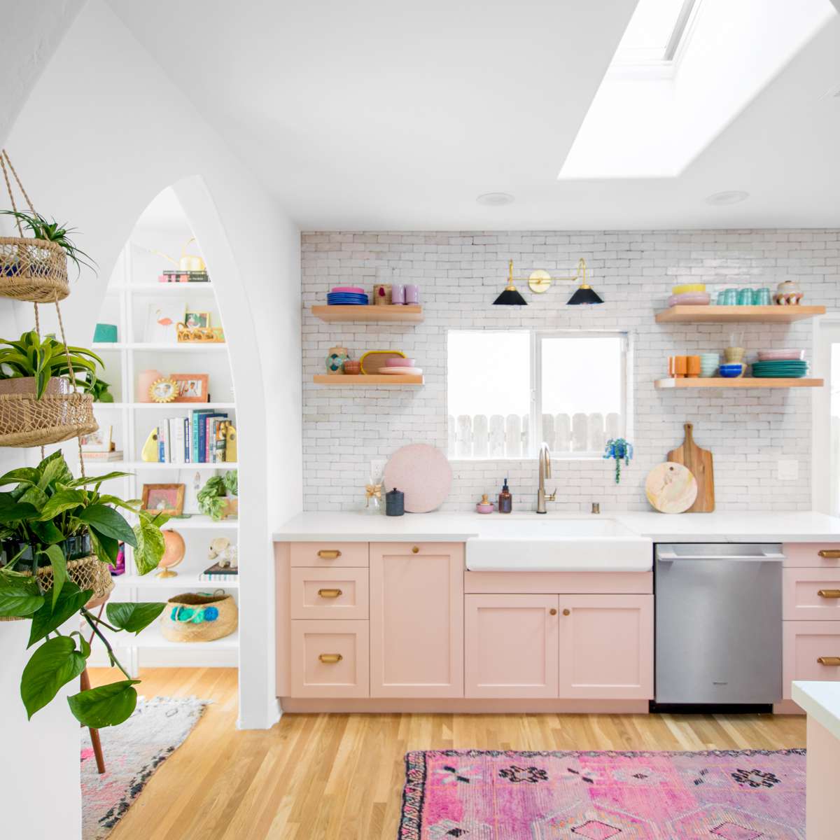 有植物和粉红色橱柜的厨房。