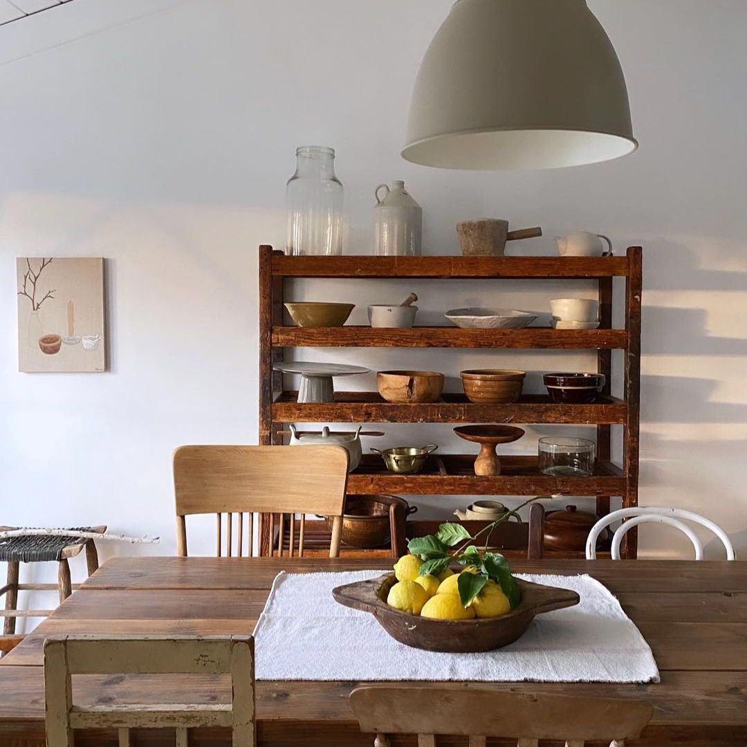 乡村厨房配有不匹配的古董椅子和展示古董盘子的架子