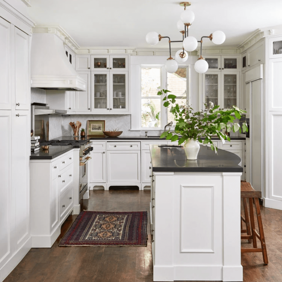 一间中世纪的现代厨房，配有醒目的灯具和暗红色地毯