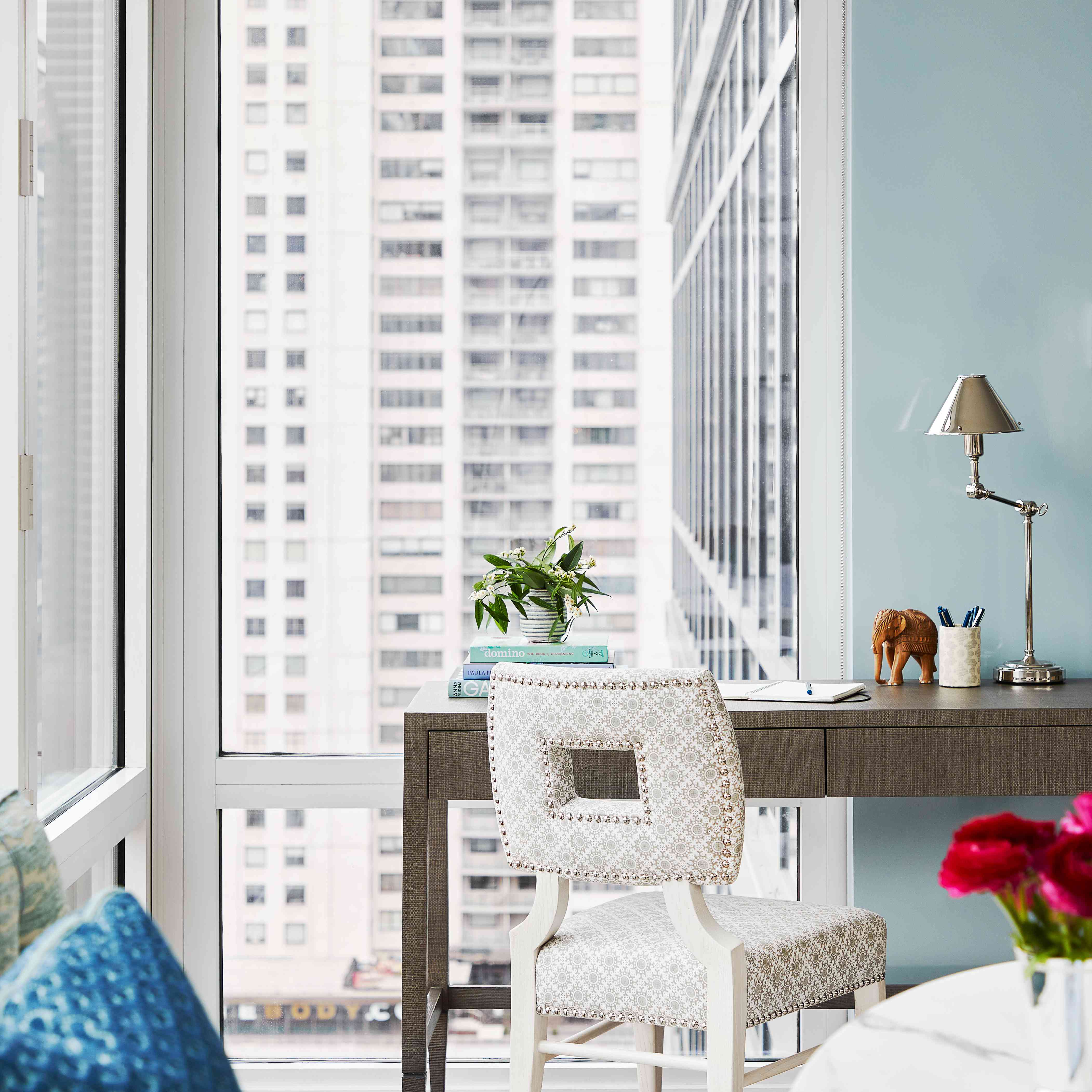 有被图案的椅子的书桌在大窗口旁边。