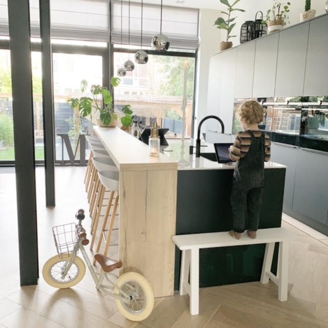 小孩男孩在小自行车旁边在厨房里。