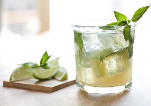 Vodka cocktail in a glass with mint and lime garnish.