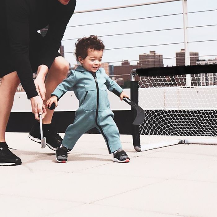 一个蹒跚学步的孩子和父母在打迷你高尔夫