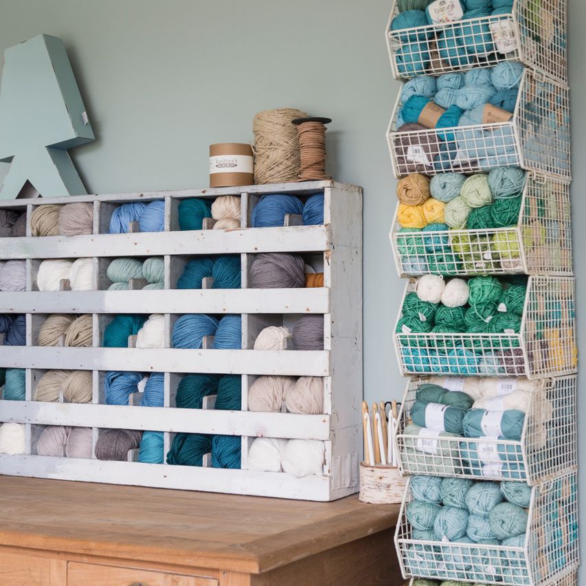 一个颜色协调的工艺室，装满了蓝色和中性色的纱线