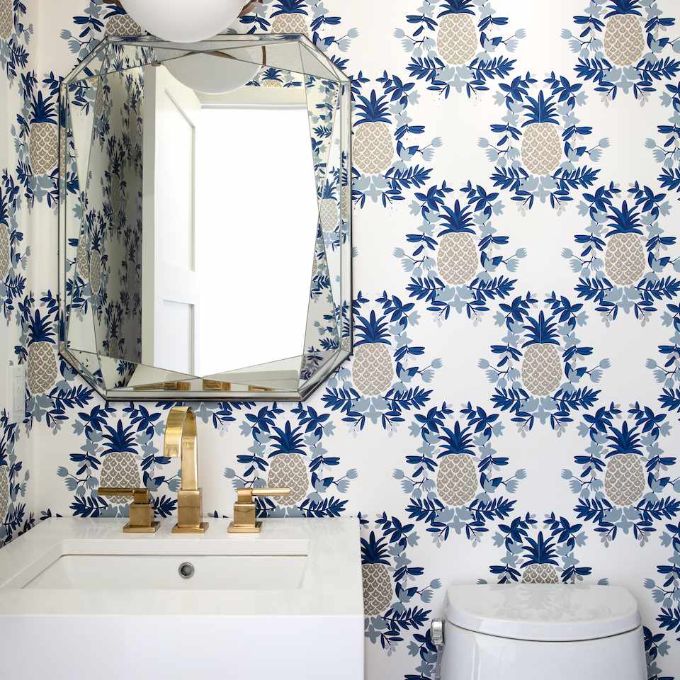 一个粉末室，带大胆的菠萝打印壁纸衬砌墙壁