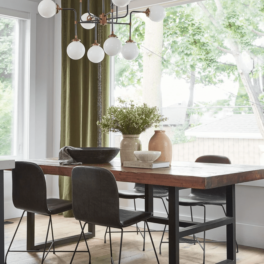 木制餐厅桌子上面有花瓶，碗和书