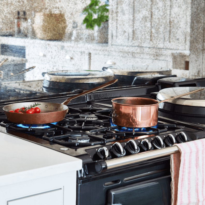 靠近带铜锅的深蓝色火炉。