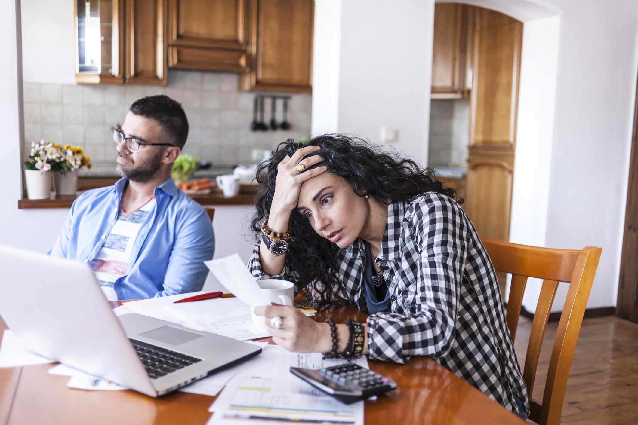 一对夫妇在笔记本电脑前看起来很沮丧