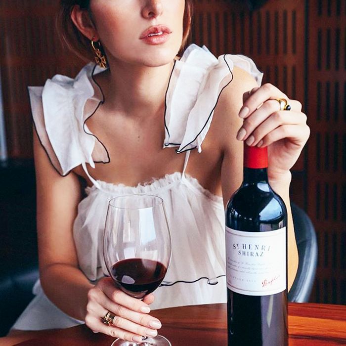 一个女人的裁剪图像拿着酒杯和酒瓶
