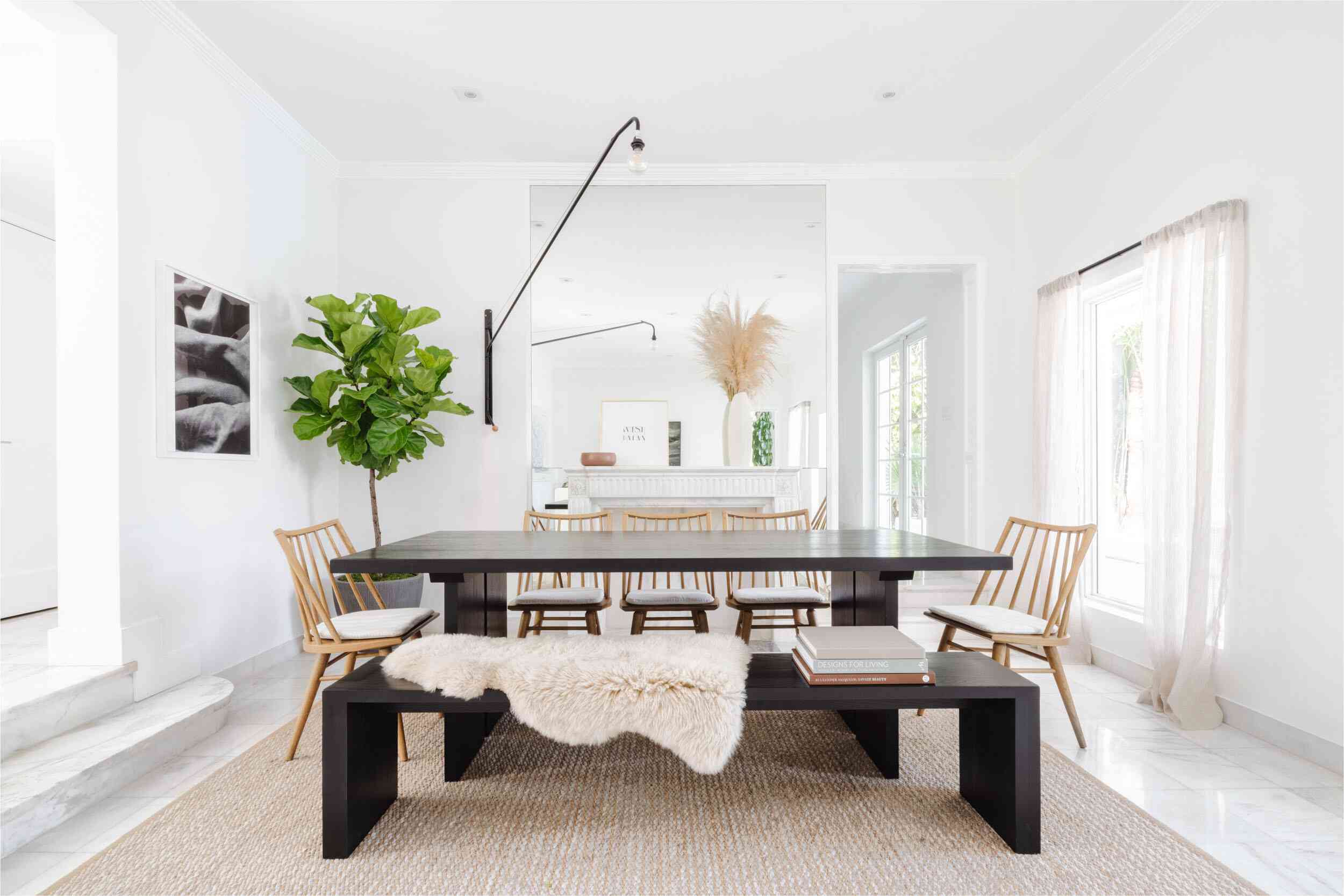 一间挂着透明白色窗帘的餐厅，挂在弯曲的窗帘杆上