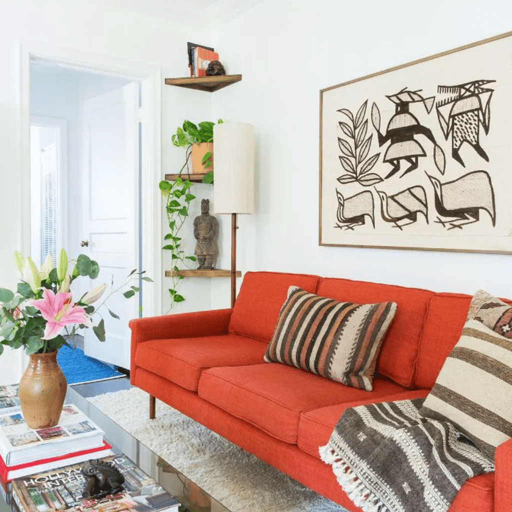 客厅里，墙角的架子旁边放着一张烧焦的橘色沙发