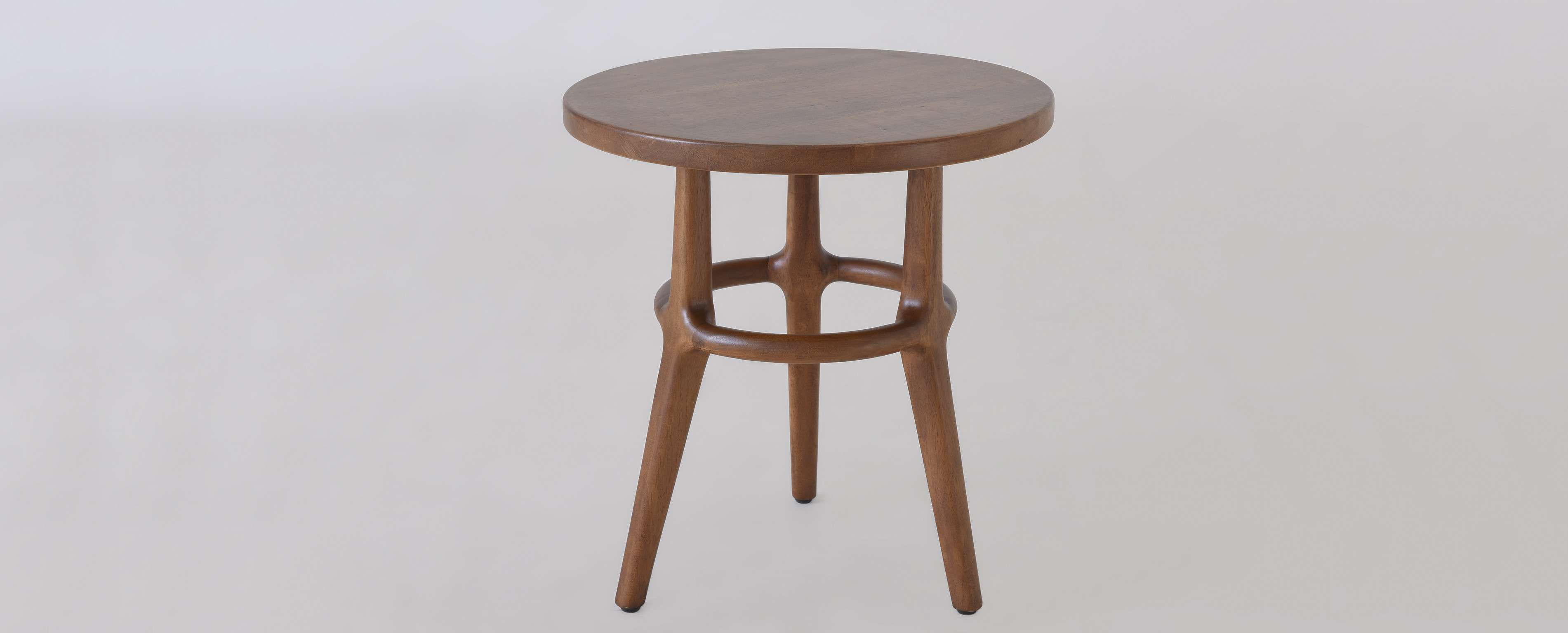 有三条腿的圆形木桌。