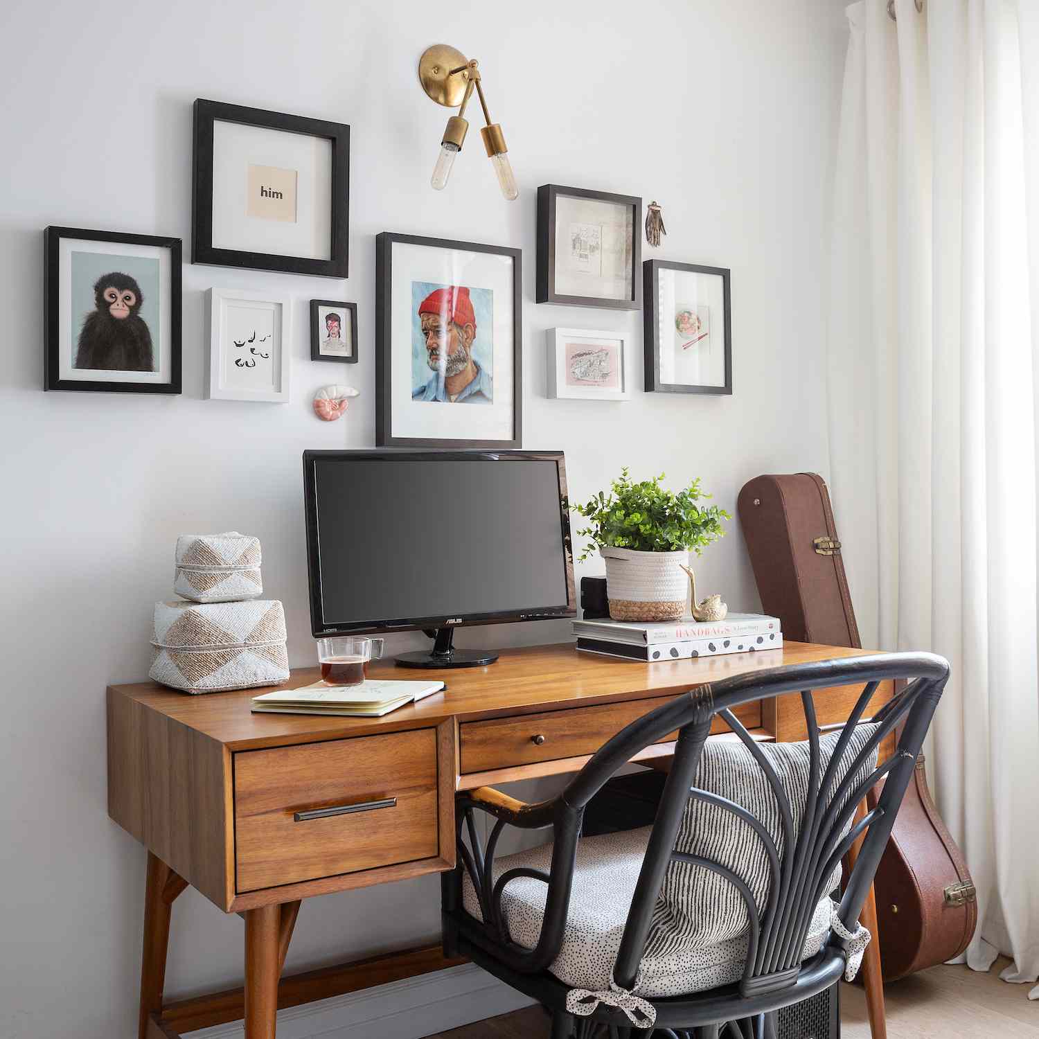 一张桌子上方挂着一面又小又宽的画廊墙