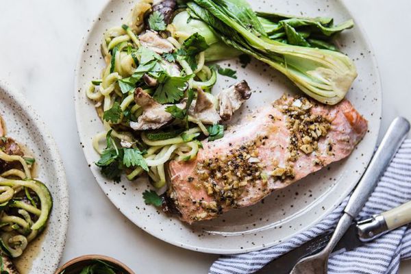 一盘三文鱼，白菜，西葫芦面条，餐巾，刀叉。