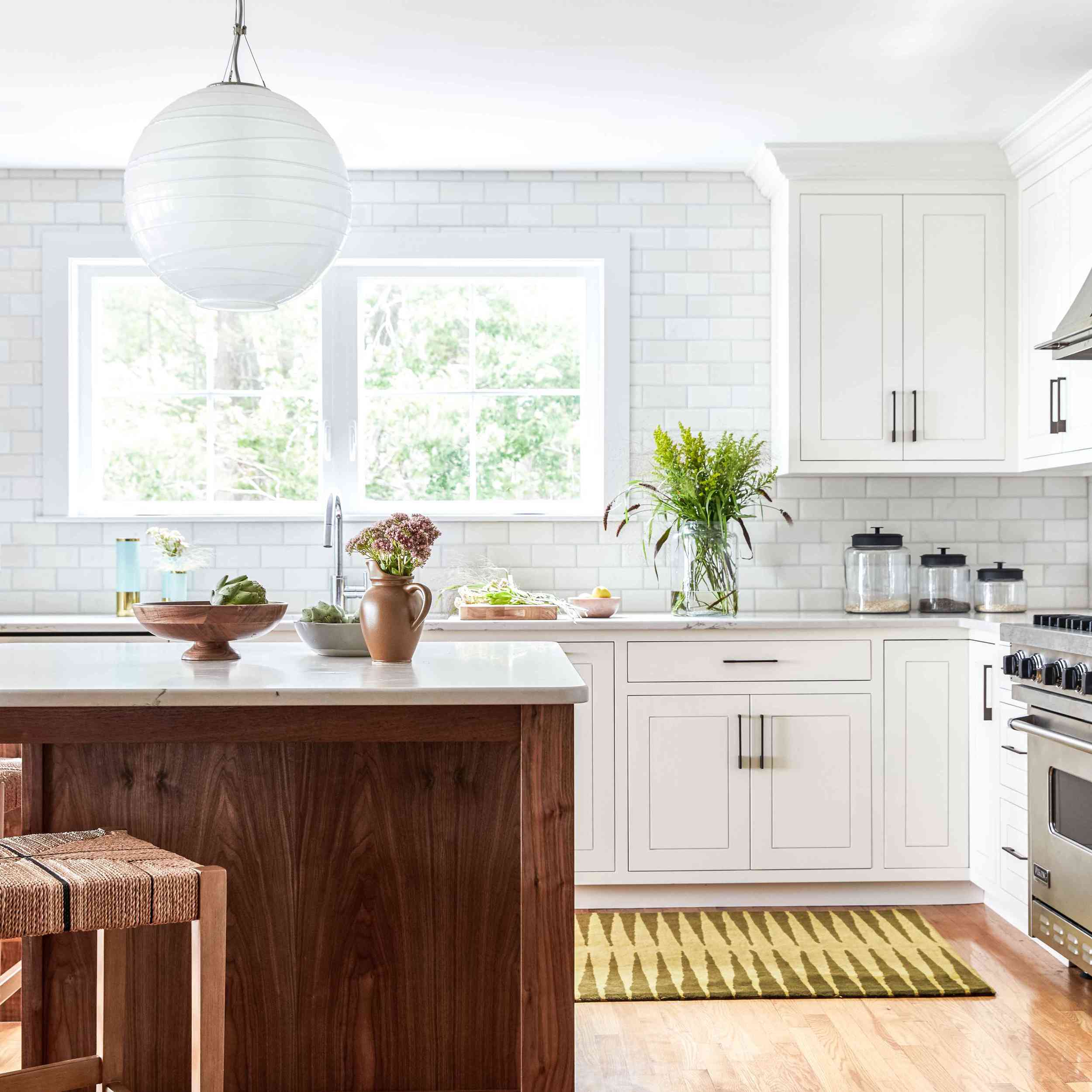 一个开放式概念厨房，带白色橱柜和黄色印花地毯