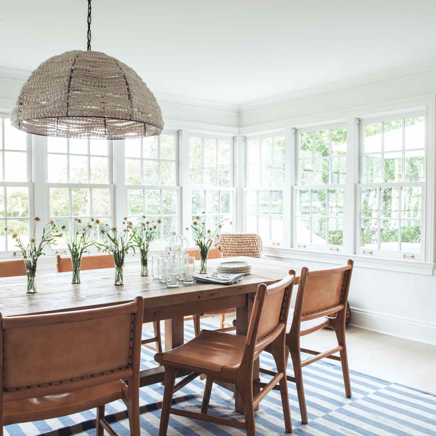 带皮革椅子，条纹地毯和串珠吊灯的餐厅