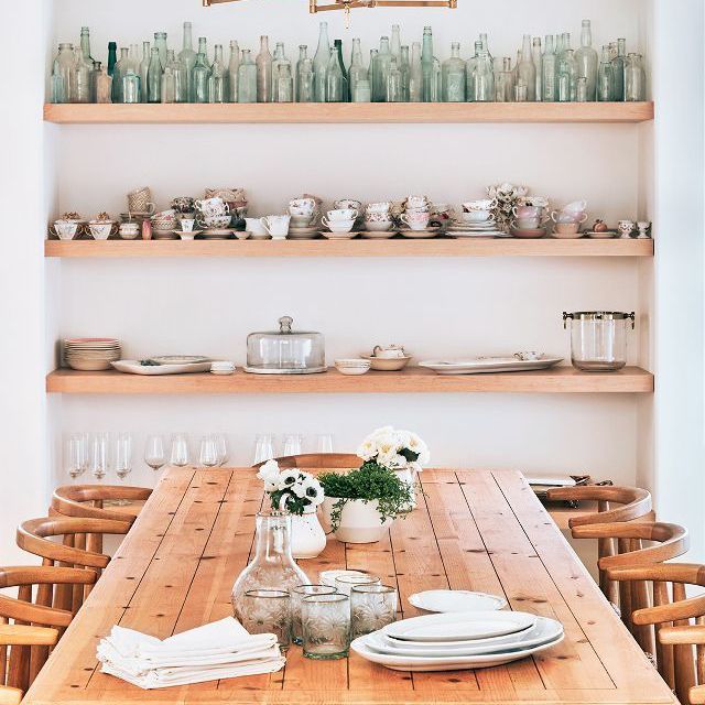 木制的餐桌，开着架子，放着玻璃杯和餐具