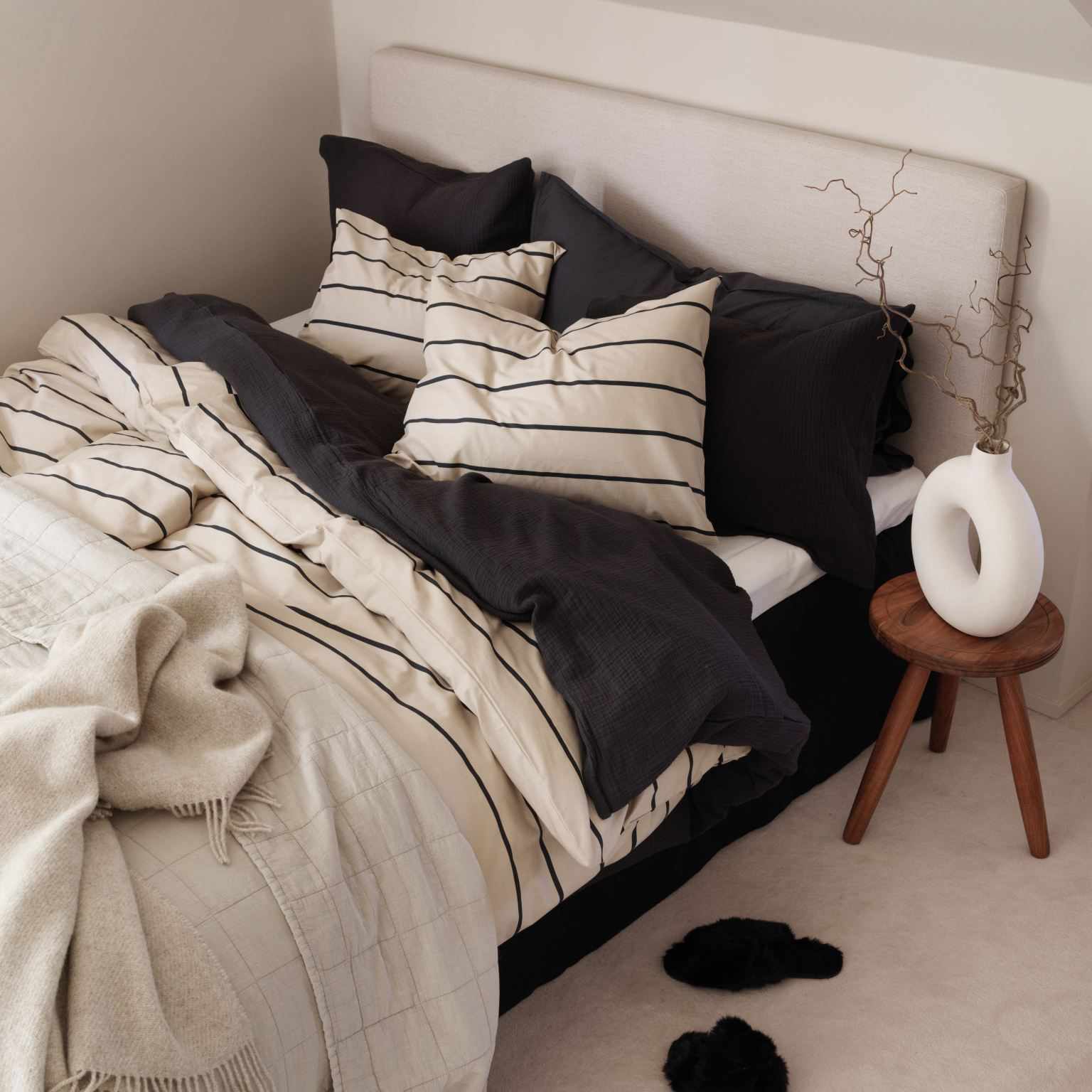 床旁边的陶瓷甜甜圈花瓶。